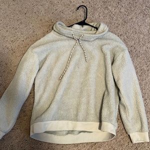 A white scoop neck sweater with draw strings